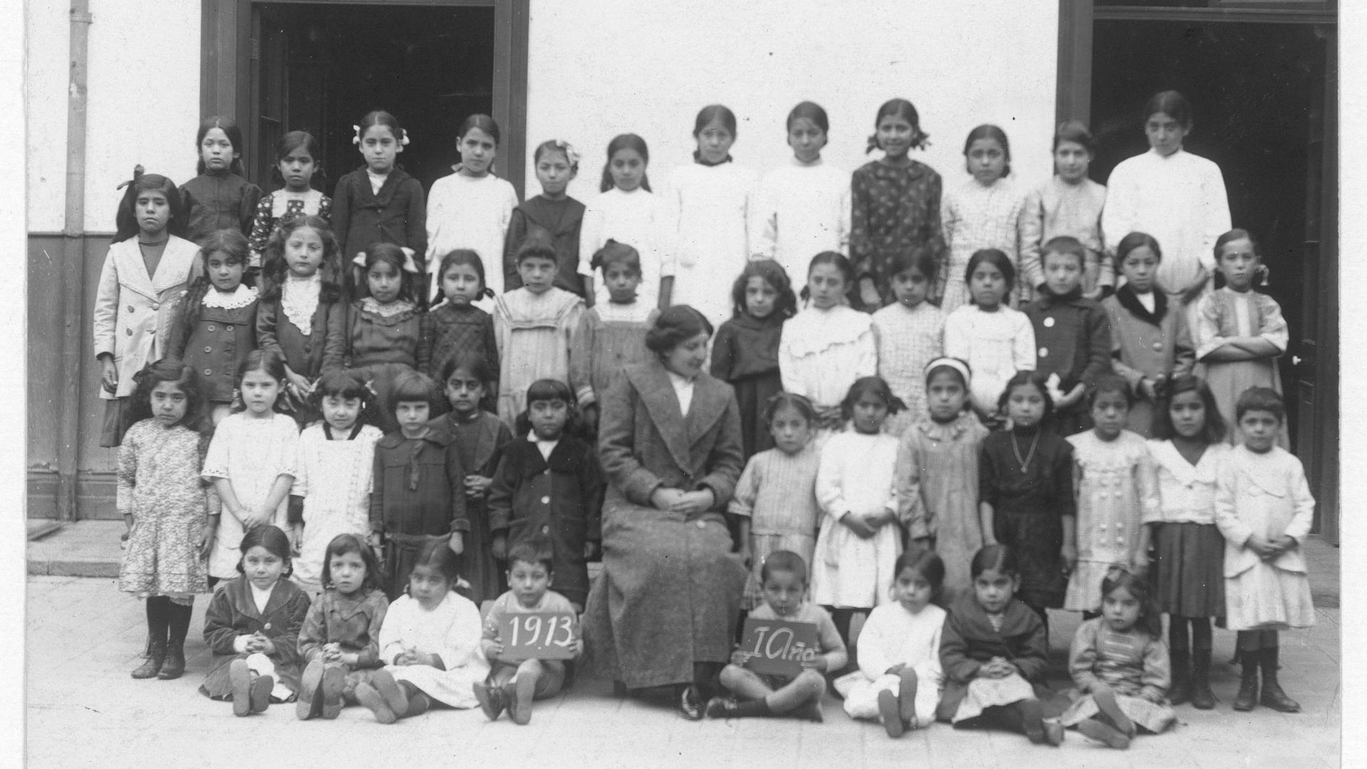 Grupo de niñas y niños junto a profesora en 1913