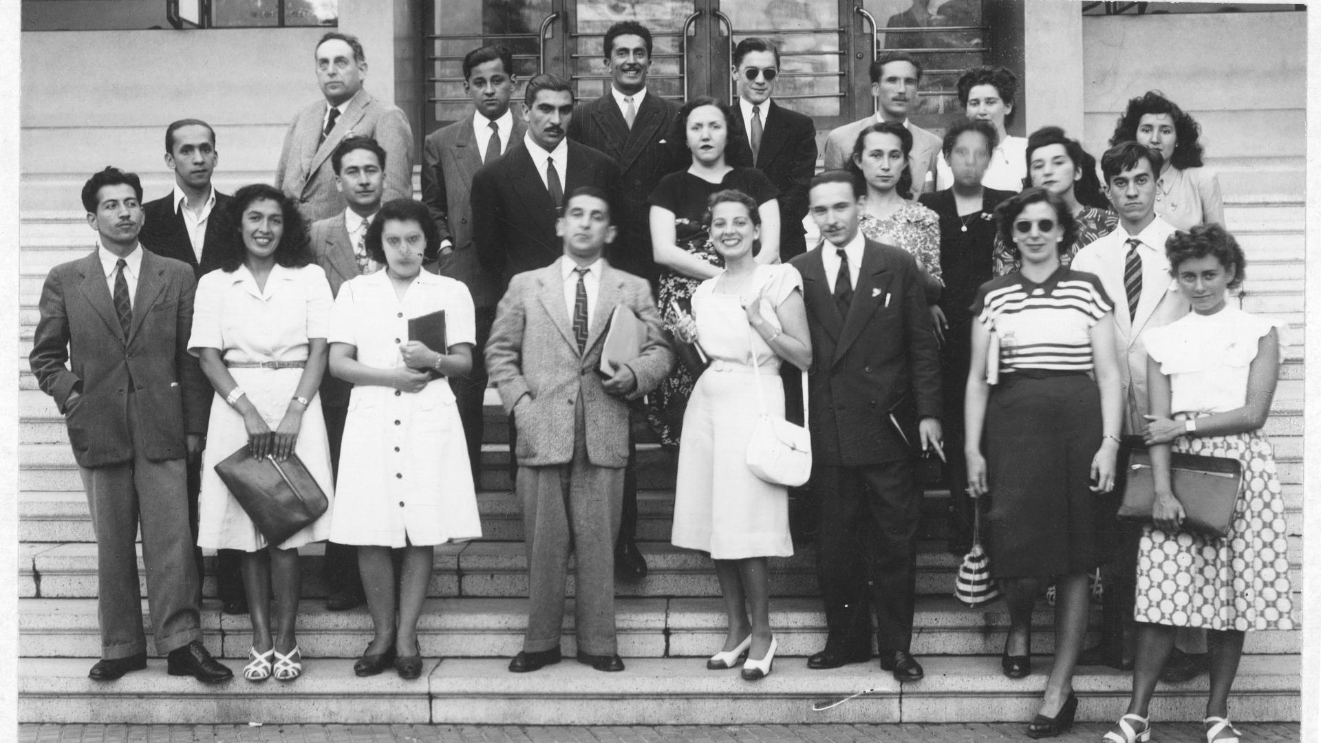 Grupo de profesoras y profesores en una escalera, foto en blanco y negro, circa década de los sesenta