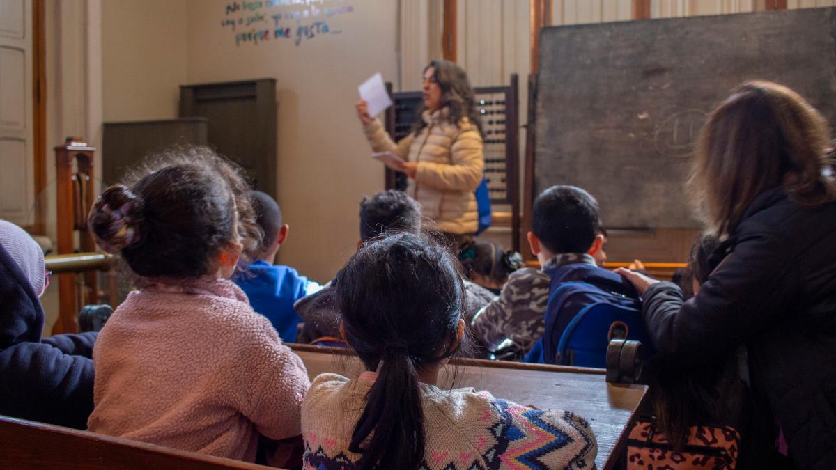 Foto de niñas y niños en la ambientación Sala de Clases del Museo de la Educación