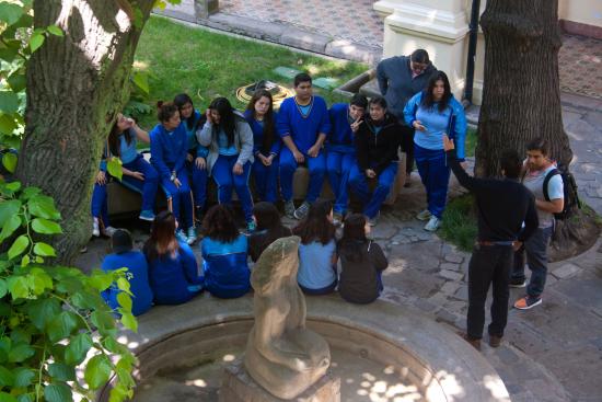 Grupo de estudiantes sentados en la pileta del patio del Museo de la Educación