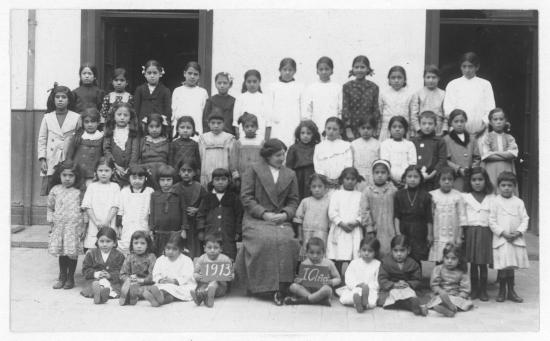 Grupo de niñas y niños junto a profesora en 1913