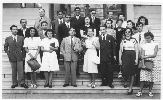Grupo de profesoras y profesores en una escalera, foto en blanco y negro, circa década de los sesenta